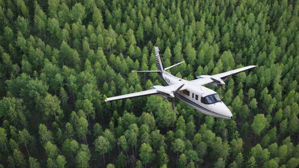 Maanmittauslaitoksen (Konekorhonen Oy:n) Rockwell Commander -kuvauskone metsän päällä